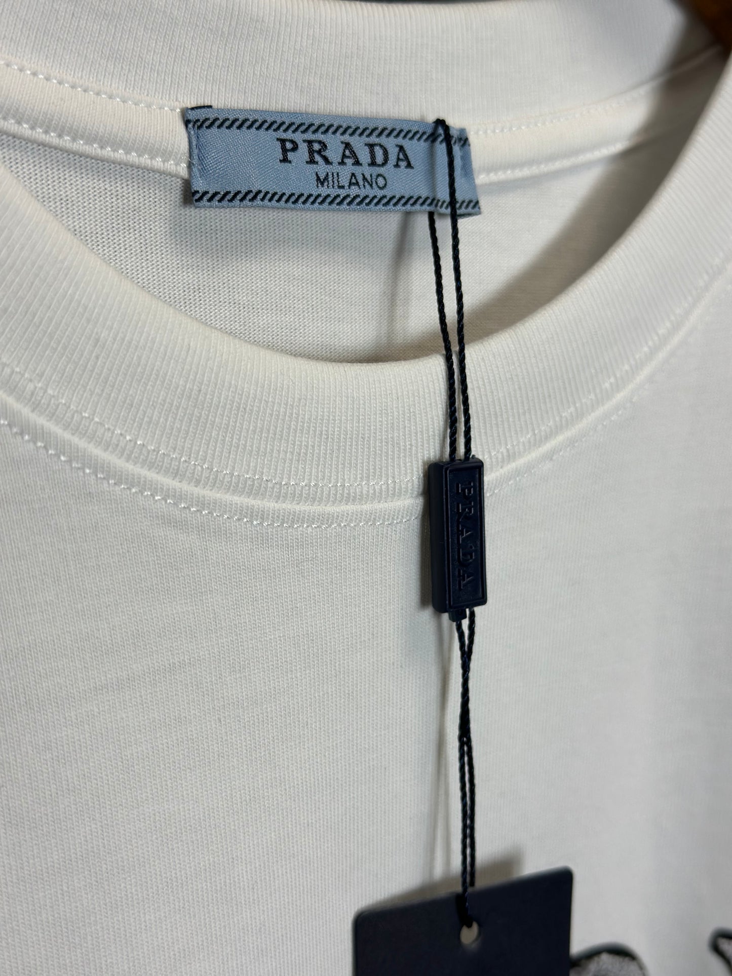 Playera Blanca Prada Milano con Logo Bordado – Estilo Clásico y Sofisticado